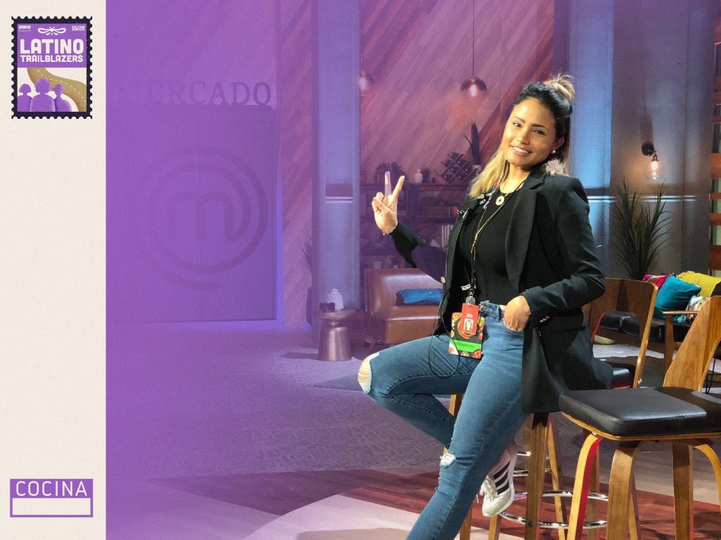 Cris Mercado, part of Latino Trailblazers, in a TV studio, sitting in a high chair, smiling to the camera. Photo courtesy of Cris Mercado.