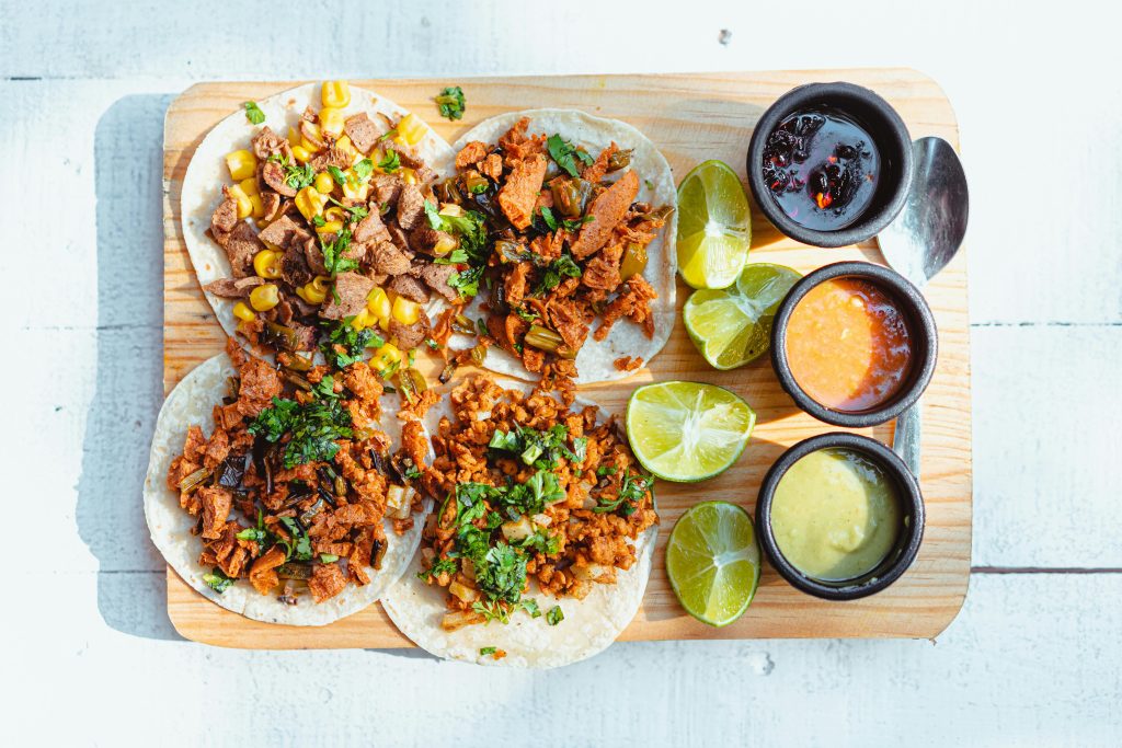 Tacos vs. Arepas -</p>
<p>Four tacos served on a table, with different sauces and sliced limes next to them.</p>
<p>Photo by Cristian Rojas via Pexels.com